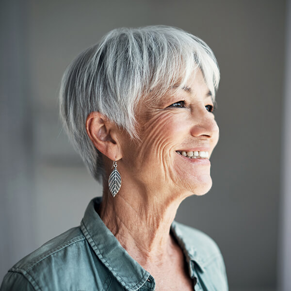 Mature woman looking out a window and smiling