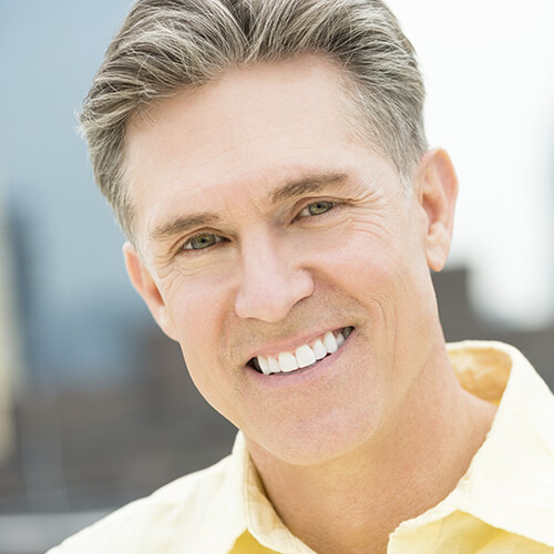 Headshot of a middle aged man with a white smile